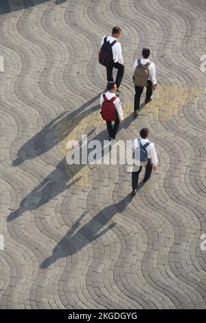 people walking on the street with shadows in sunny day, in the photo from the top of the building. (Surabaya, Indonesia -  October 27, 2018) Stock Photo