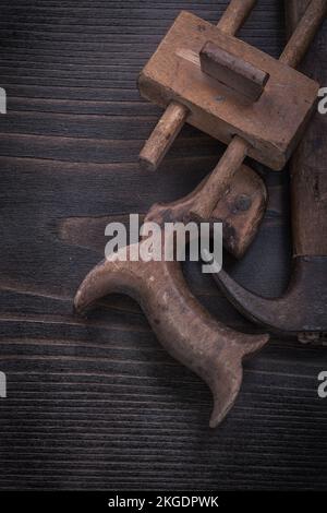 Composition of dark hand saw vintage marking gauge claw hammer. Stock Photo