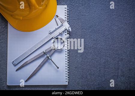 Copybook hard hat pair of compasses slide caliper construction concept. Stock Photo
