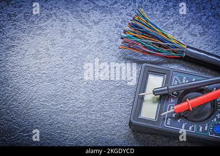 Digital multimeter electric tester wires on black background electricity concept. Stock Photo