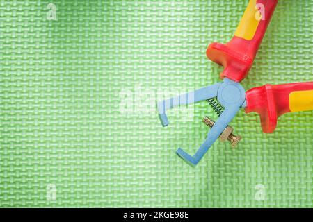 Insulated wire strippers on green background electricity concept. Stock Photo