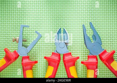 Insulated wire strippers pliers nippers on green background electricity concept. Stock Photo