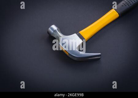 horizontal view very close up view claw hammer with yellow and rubber handle on black background Stock Photo