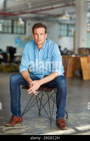Focused on his career goals. Portrait of a handsome young designer sitting on a chair in an office. Stock Photo