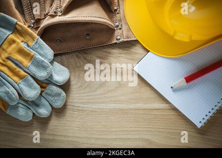 Leather tool belt safety gloves hard hat notebook pencil. Stock Photo