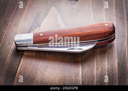 agricultural knife on vintage wooden board close up Stock Photo