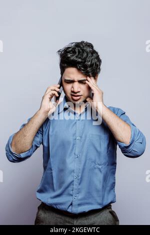 Indian Model or Actor in Formal Attire Looking Anxious While on Phone, Dealing with Missed Opportunity and Professional Mistake. Addressing Missed. Stock Photo