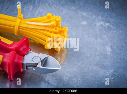 Sharp nippers cable ties on metallic background construction concept. Stock Photo