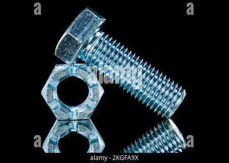 Threaded crown nuts bolts on black background horizontal view. Stock Photo
