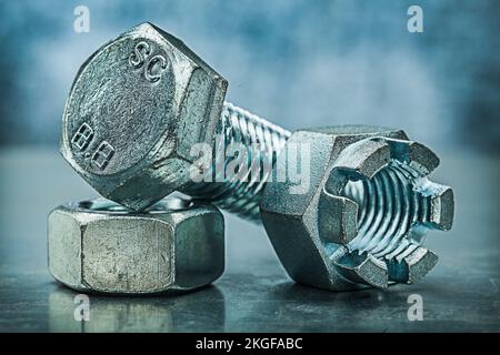 threaded crown nuts and bolt on metalic background Stock Photo