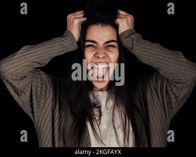 Stress, anxiety and woman screaming with frustrated, depressed of mental health problem feeling. Portrait of a young female from Spain with anger and Stock Photo