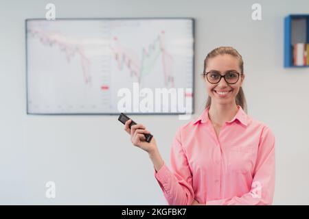 On Stage, Successful Female Speaker Presents Technological Product, Uses Remote Control for Presentation, Showing Infographics, Statistics Animation Stock Photo