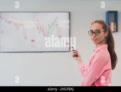 On Stage, Successful Female Speaker Presents Technological Product, Uses Remote Control for Presentation, Showing Infographics, Statistics Animation Stock Photo