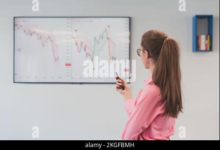 On Stage, Successful Female Speaker Presents Technological Product, Uses Remote Control for Presentation, Showing Infographics, Statistics Animation Stock Photo