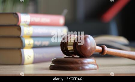 Judge gavel or hammer on sounding block and stack of law books on table Stock Photo