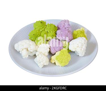 White, pink and green cauliflower on a plate on a wooden table Stock Photo