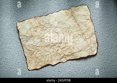 Vintage crumpled sheet of paper on grey surface. Stock Photo