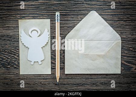Vintage envelope paper sheet angel pencil on black board. Stock Photo