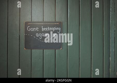 Door, sign and beekeeping with a chalkboard hanging on an entrance way of a small business in agriculture. Wood, store and retail with a notice on a Stock Photo