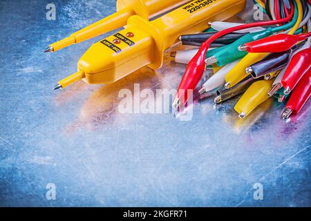 Yellow electrical tester assortment of crocodile clip cables on metallic background electricity concept. Stock Photo