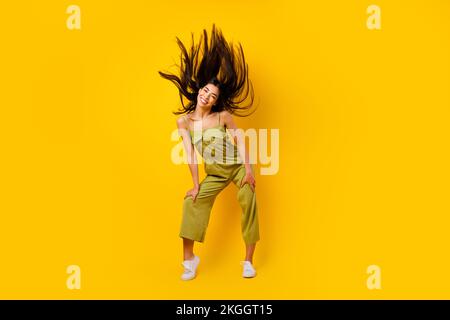 Full size portrait of pretty positive filipino lady flying hairdo have good mood isolated on yellow color background Stock Photo