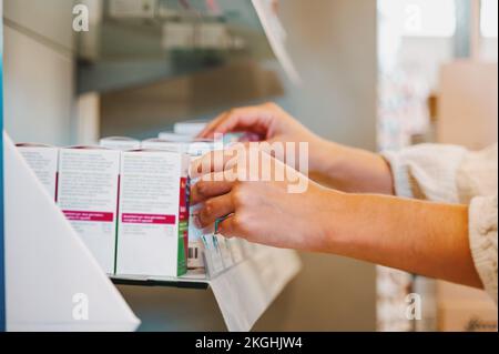 Woman working in the pharmacy looks for the medicine Stock Photo