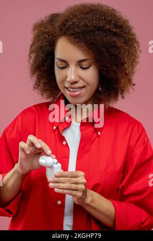 Young woman using wireless headphones and looking contented Stock Photo