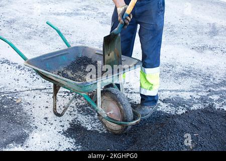 asphalt in wheelbarrow operator prepares mixture with uniform Stock ...