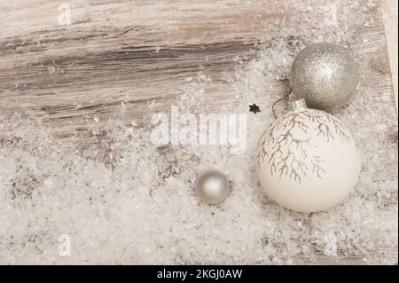 Christmas Wooden gray background with artificial snow and silver Christmas decorations Stock Photo