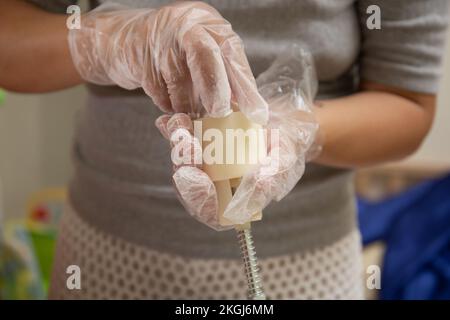 A Female hands with transparent gloves Making Mooncake in a plastic mould Stock Photo