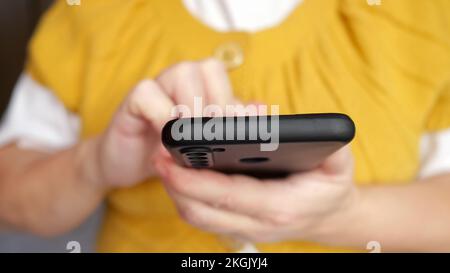 Hand of senior woman typing message to friend on smartphone Stock Photo