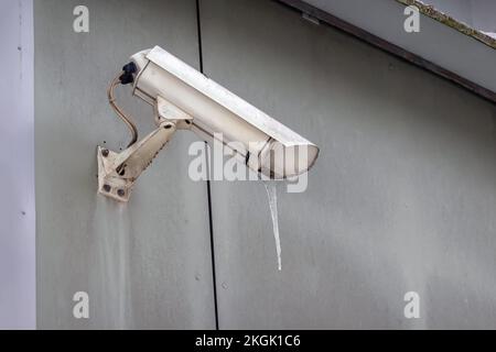 Security camera hanging on the wall. Surveillance CCTV camera. Nobody Stock Photo