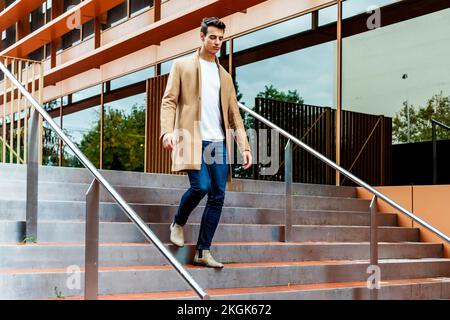 Man outdoor in winter fashion, wearing woolen jacket in city downstairs Stock Photo