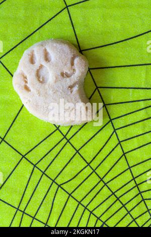 Small Halloween themed all butter shortbread cookie biscuit ghoul ghost on green Halloween serviette napkin Stock Photo