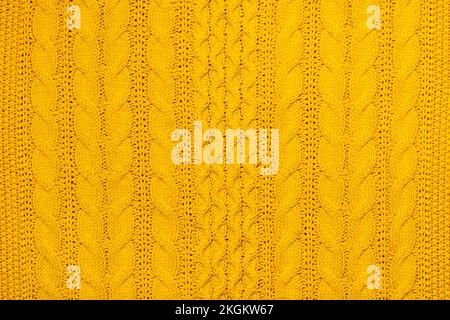 Bright yellow macro photo of textured jersey and knitting of sweater or sweatshirt. Pattern and background for fashion Warm Autumn concept. Stock Photo