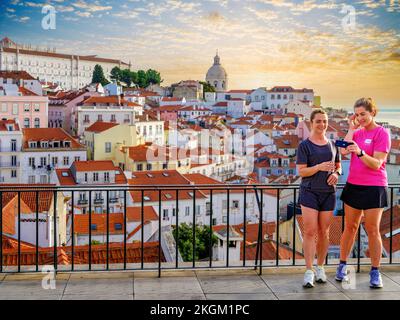 Panoramic Cityscape of historic Alfama  with the National Pantheon and  Sao Vicente de Fora Monastery, Two women taking Selfies with this beautiful ba Stock Photo