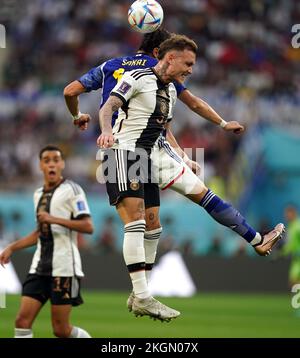 Germany's David Raum and Japan's Hiroki Sakai battle for the ball during the FIFA World Cup Group E match at the Khalifa International Stadium, Doha. Picture date: Wednesday November 23, 2022. Stock Photo