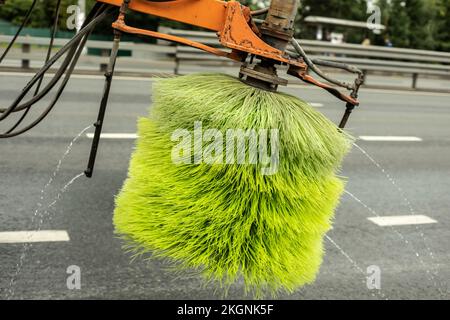 Washing car on road. Brush for washing asphalt. Special equipment in city. Spraying water on highway. Utilities. Stock Photo