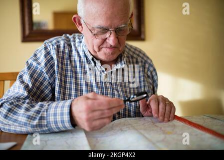 Senior man looking at a road map using magnifier Stock Photo