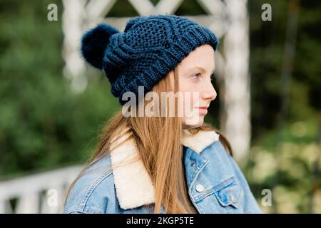 Portrait of teenage girl wearing woolly hat, looking sideways Stock Photo