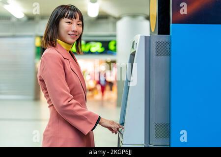 Woman buying ticket from ticket machine Stock Photo