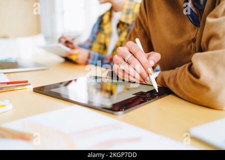 Graphic designer with digitized pen using tablet PC at desk Stock Photo