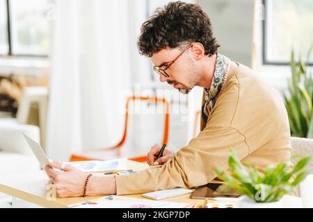 Young graphic designer working on laptop at desk in office Stock Photo
