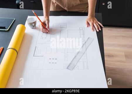 Architect working on blueprint leaning on table Stock Photo