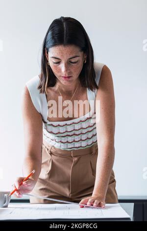 Young architect working on blueprint in office Stock Photo