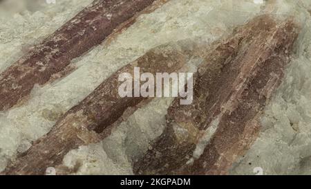 Reddish Tourmaline stone on matrix against Black Background Stock Photo