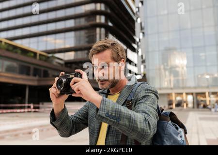 Man taking photos with camera in city Stock Photo