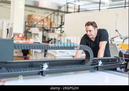 Professional worker printmaker technician operator works in printing ...