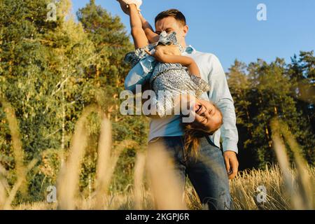 Happy father having fun with daughter at field Stock Photo