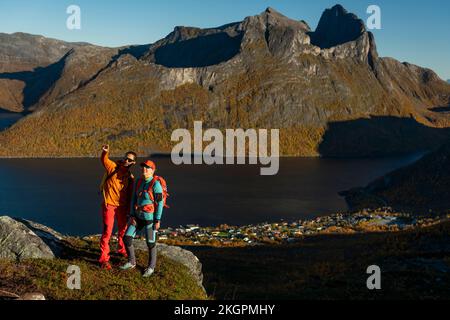 Couple standing on top of mountain and gesturing at sunny day Stock Photo